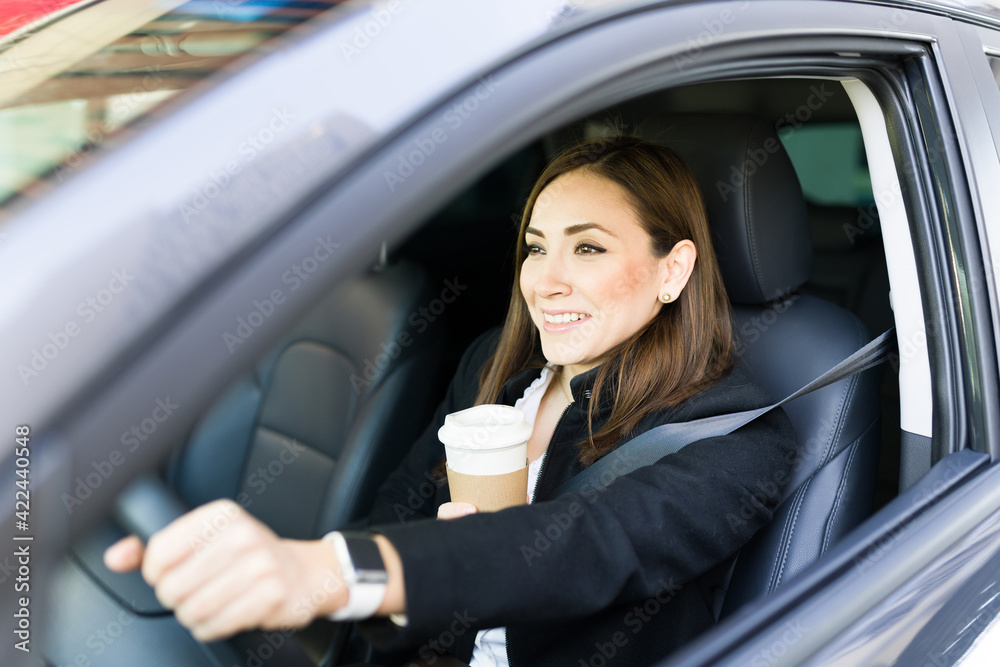 Smiling professional woman with coffe while driving