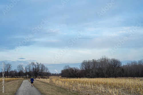 A man jogs through a field in rural Wisconsin