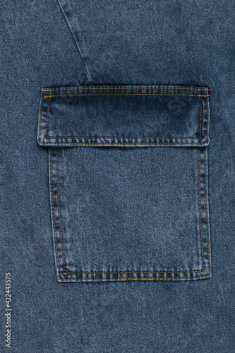 Blue denim background with large patch pocket.