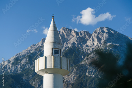 Minaret tower of a mosque in front of sunny Austrian Alps in Telfs, Tirol, Austria photo