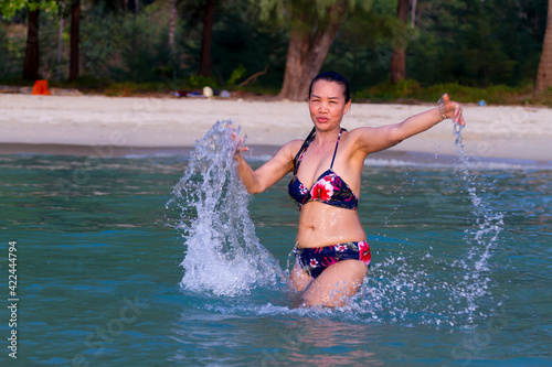 Woman in bikini play water at beach