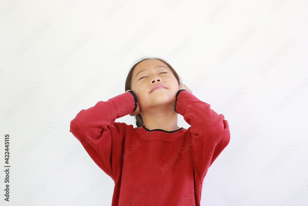 Portrait of happy Asian little child placing hands on ears. Joyful kid closed eyes and smiling on white isolated background Portrait of happy Asian little child placing hands on ears. Joyful kid closed eyes and smiling on white isolated background