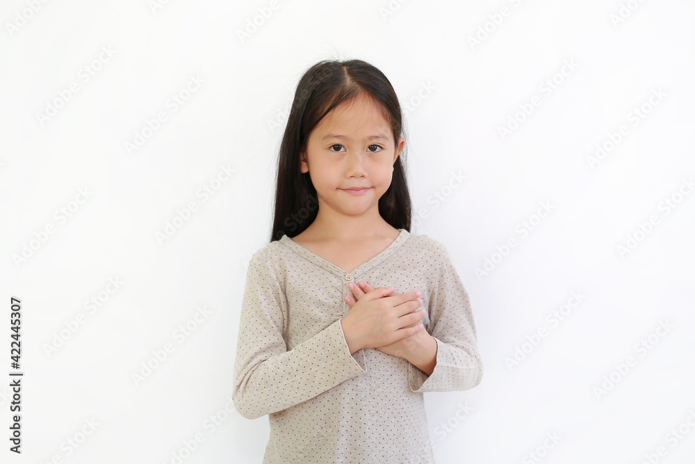 Asian little child girl holding hands on chest isolated on white background. Kid place arms on heart gesture of love. Asian little child girl holding hands on chest isolated on white background. Kid place arms on heart gesture of love.