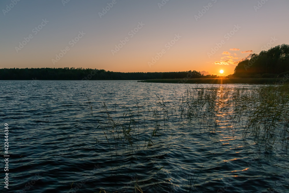 Setting sun on a lake on a summer evening - beautiful landscape