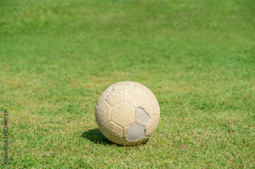 Old soccer ball on green grass of soccer field. © Lifestyle Graphic
