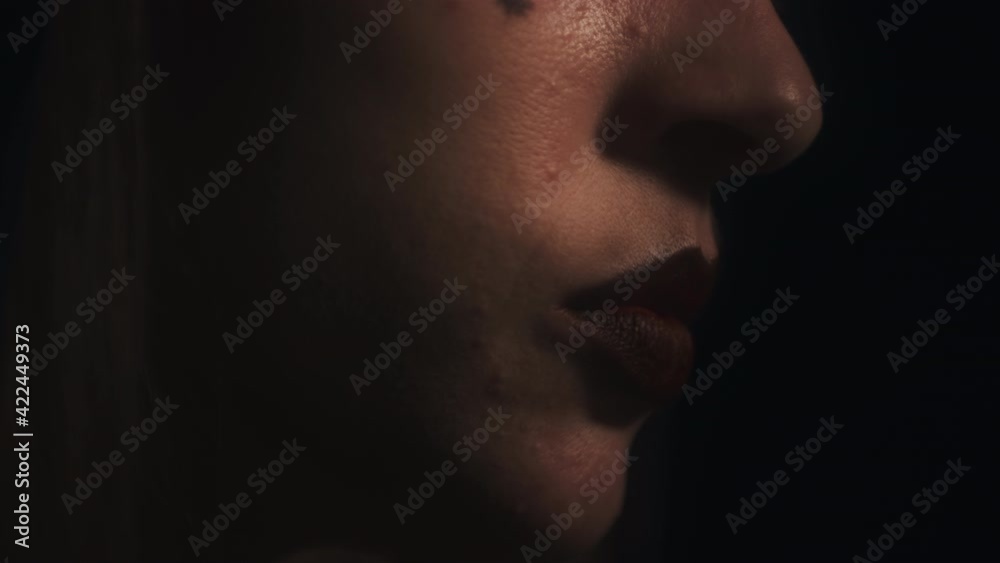 Closeup Profile of Meditating Woman's Face Mouth Chanting with Black Background Closeup Profile of Meditating Woman's Face Mouth Chanting with Black Background