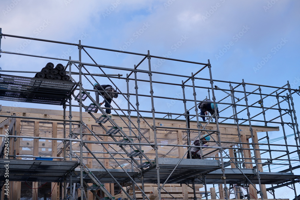 A worker at the housing construction site with wooden Framework construction, TOKYO, JAPAN - 18TH FEB 2021.