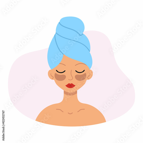 Beautiful girl with patches on her eyes and a towel on her head. The woman takes care of the skin of the face.