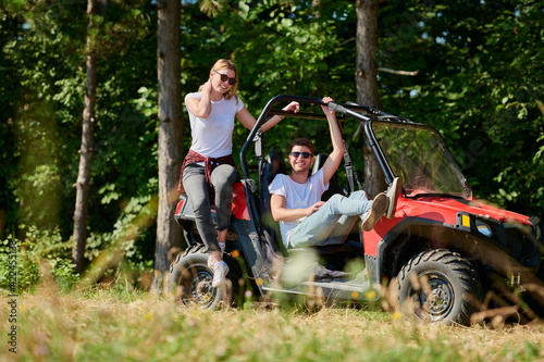 couple enjoying beautiful sunny day while driving a off road buggy