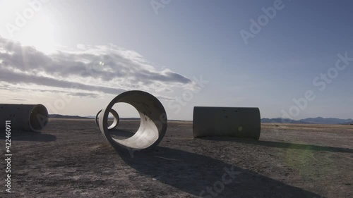 Panning view of the Lucin Sun Tunnels in the Utah desert looking towards the sun. photo