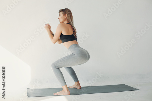A beautiful girl is engaged in a yoga studio