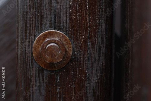 Nut bolt with macro look and blur in round wood with a dark brown wood look