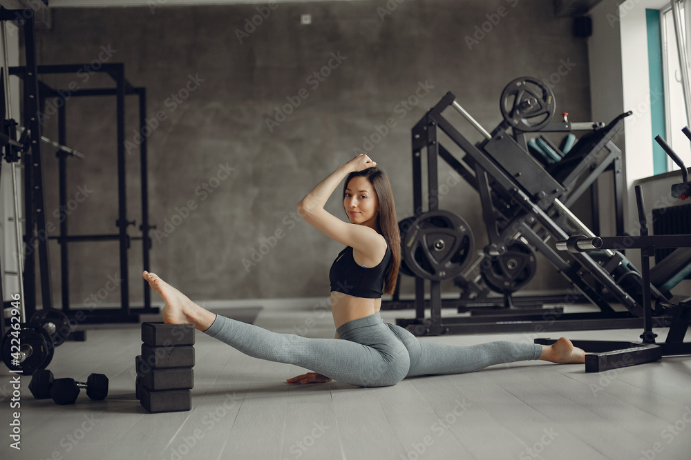 Fototapeta premium A beautiful girl is engaged in a gym