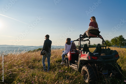 group young happy people enjoying beautiful sunny day while driving a off road buggy car