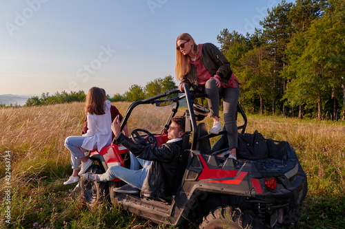 group young happy people enjoying beautiful sunny day while driving a off road buggy car © .shock