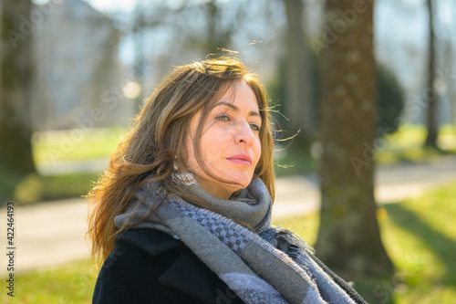 Attractive woman sitting daydreaming in a park in early spring