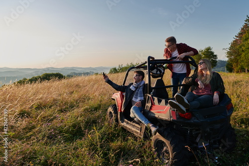 group young happy people enjoying beautiful sunny day while driving a off road buggy car © .shock