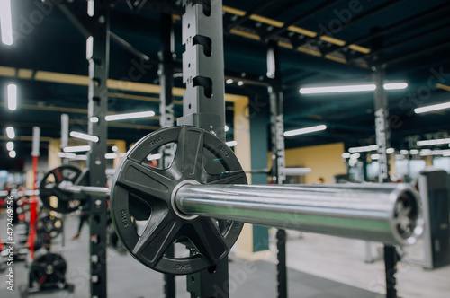 Panoramic shot of woman working out with barbell in gym