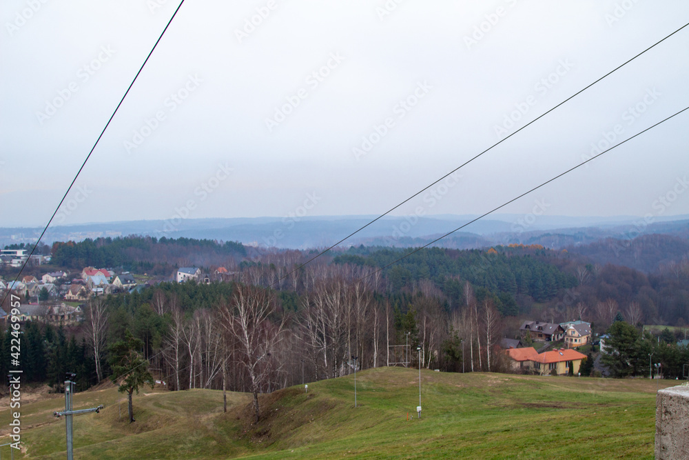 Ski resort not working. Warm winter. Global warming. Ski lifts. Green hills, no snow, no people.