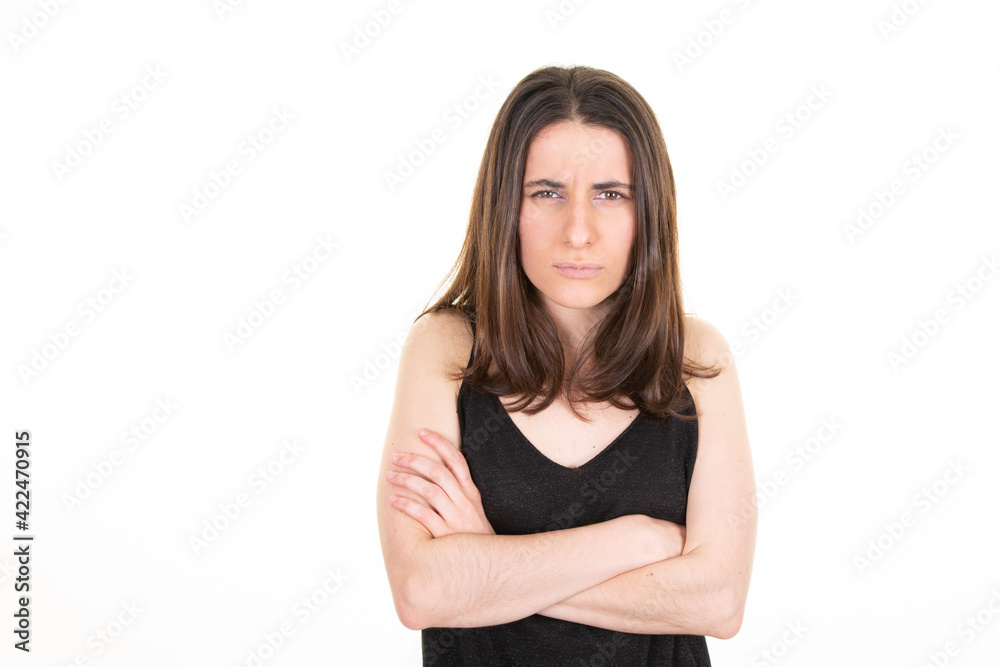 Portrait of sad angry woman standing with arms crossed aside blank copy space on white background Portrait of sad angry woman standing with arms crossed aside blank copy space on white background