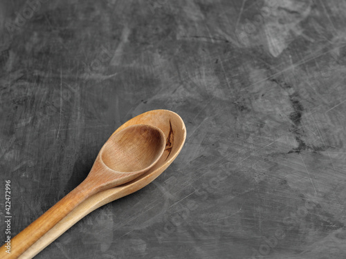 Two wooden spoons lie on a gray table top view.