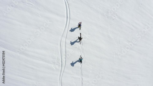 Splitboard or ski touring drone shot of three persons from above.