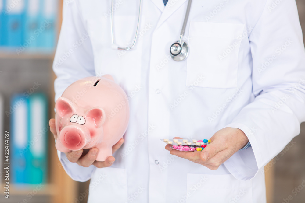 doctor with stethoscope holding piggy bank and pills - obrazy, fototapety, plakaty 