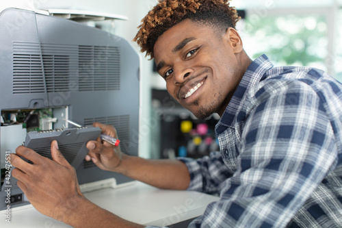 a young man fixing printer