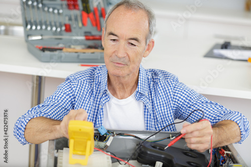 a mature man repairing a machine