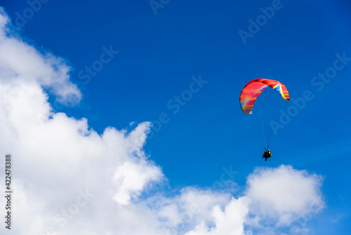 Paragliding extreme Sport with blue Sky and clouds on background Healthy Lifestyle and Freedom concept