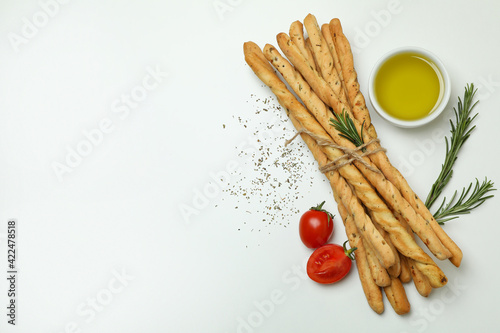 Grissini breadsticks with spices on white background photo