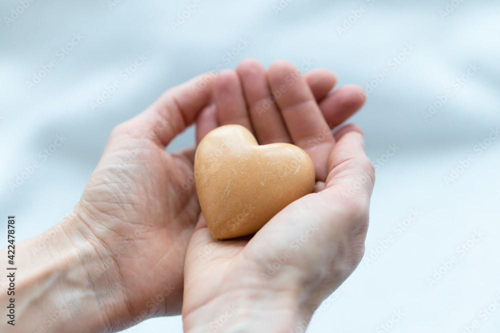 stone like heart holded in hands. concept of charity, love, donate and helping hand. International cardiology day stone like heart holded in hands. concept of charity, love, donate and helping hand. International cardiology day