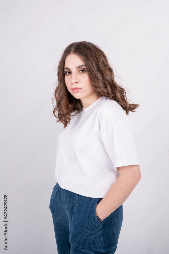 Fashionable redhair woman in hoodie, skirt and stylish rough shoes sitting on pouf in studio Fashionable redhair woman in hoodie, skirt and stylish rough shoes sitting on pouf in studio