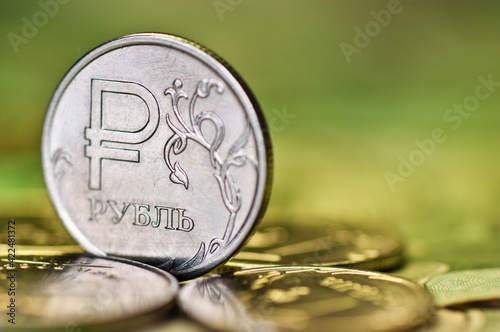 One rouble coin among other ruble coins against green background. Russian money photo