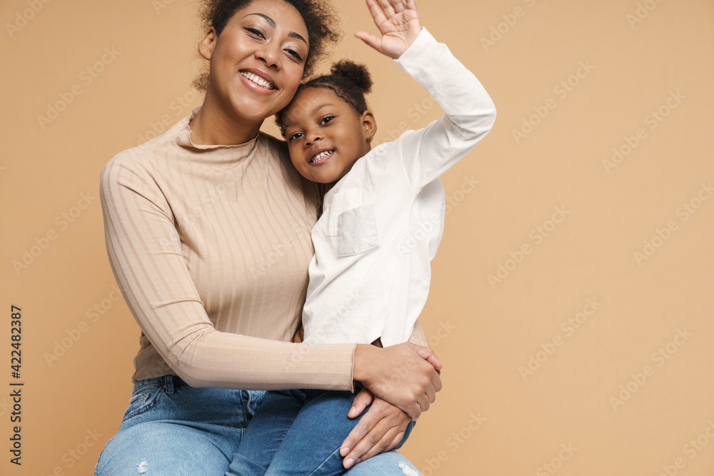 Happy black mother and daughter hugging and waving hand Happy black mother and daughter hugging and waving hand