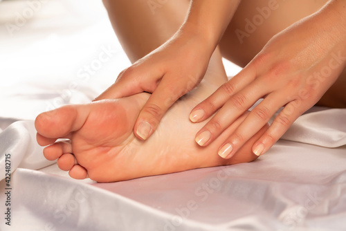 Feet massage of woman, close up, isolated on white background.