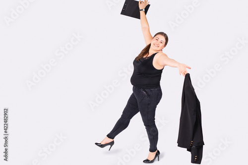 Body positive. Love your body. Happy plus size woman dance and active lifestyle. Full length portrait of beautiful and elegant plus size blonde woman celebrating success over gray background