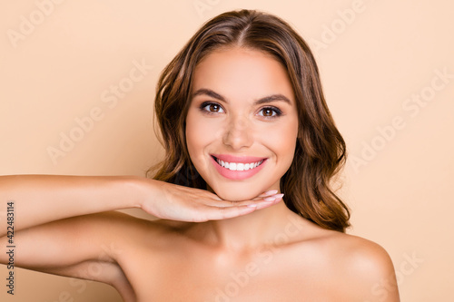 Photo of nice long hairdo optimistic lady without clothes hand face isolated on pastel beige color background