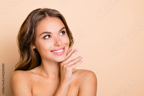 Photo of nice long hairdo optimistic lady without clothes hand face look empty space isolated on pastel beige color background