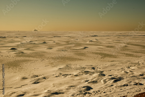 icy desert with a passing ship