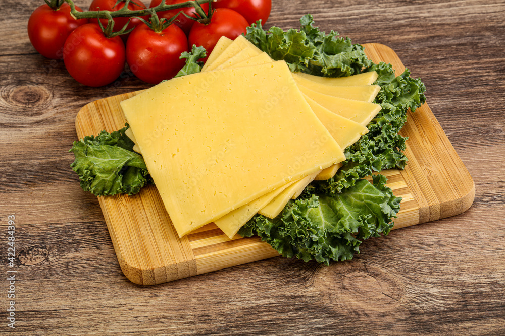 Sliced Gauda cheese over board Sliced Gauda cheese over board
