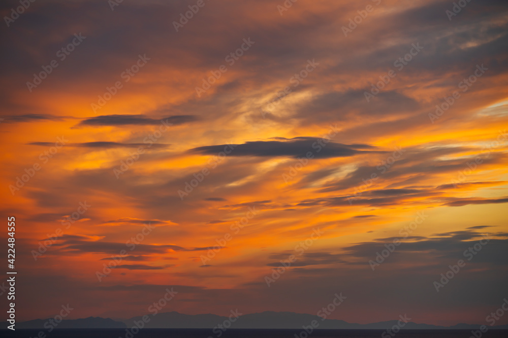 The fantastic pastel colors of the clouds at sunset in an ocean bay