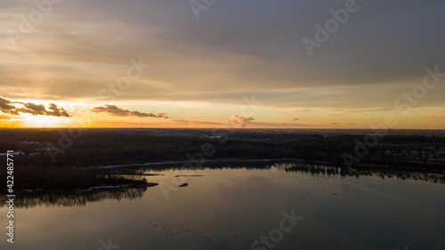 Aerial view of a beautiful and dramatic sunset over a forest lake reflected in the water  landscape drone shot. Blakheide  Beerse  Belgium. High quality photo