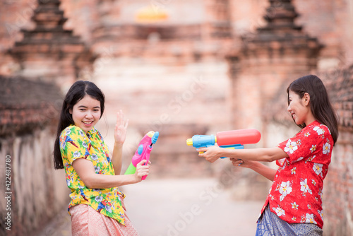Thai girl smiling Asian beauty holding plastic water gun Preserve the good culture of Thai people during Songkran festival. Thai New Year, Family Day in April .Selective focus