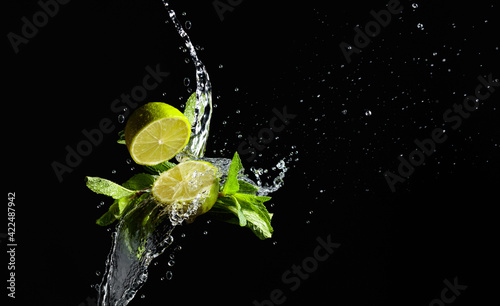 Lime, mint, and water splashes on a black background.