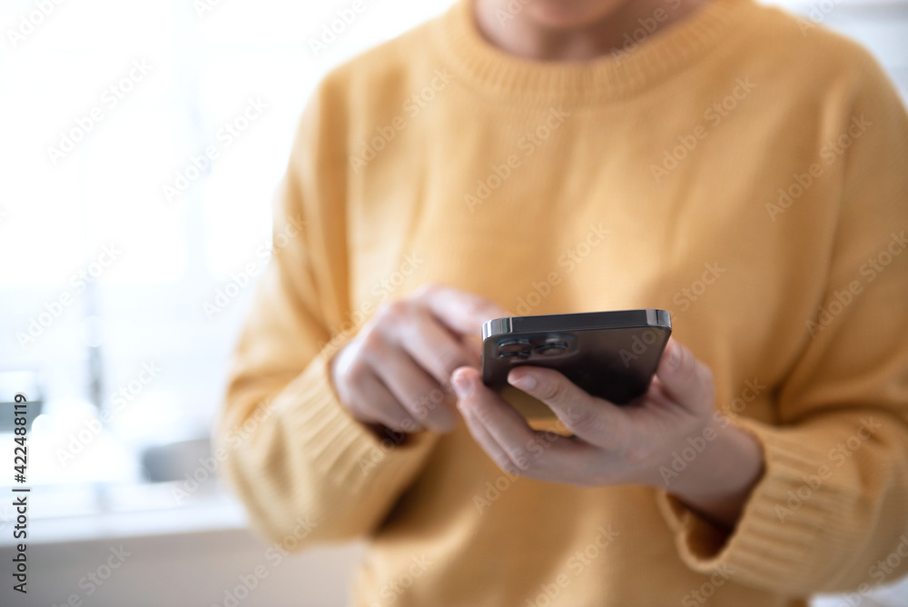 Fototapeta premium Closeup female using smartphone at home, she chatting Online Messaging and social network on mobile.