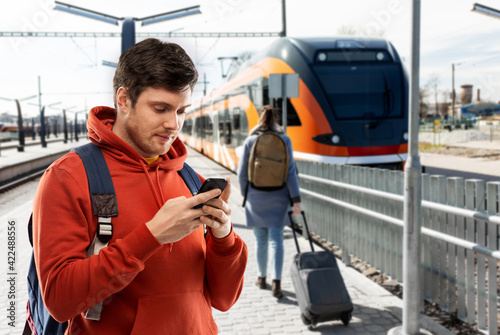 man with smartphone traveling by train