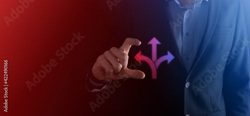 Businessman in a suit holds a sign showing three directions. in doubt, having to choose between three different choices indicated by arrows pointing in opposite direction concept. three ways to choose