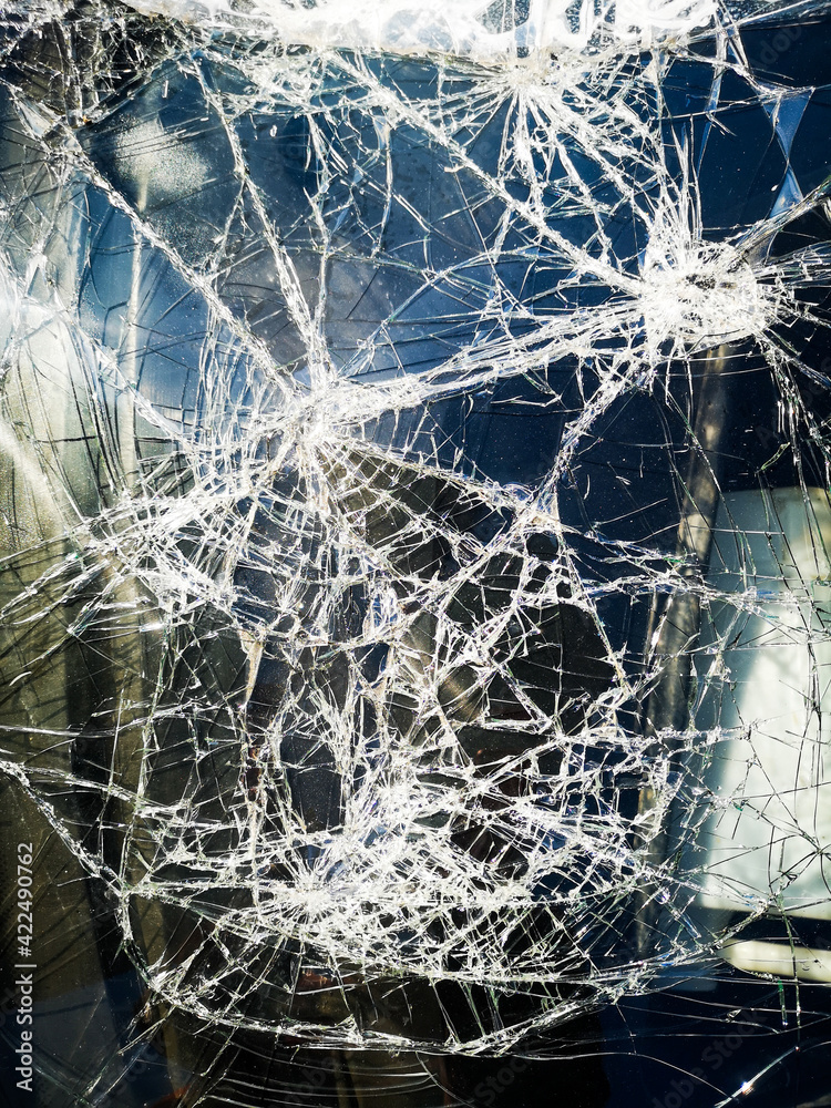Stockfoto background furious white cracks on the dark windshield of the