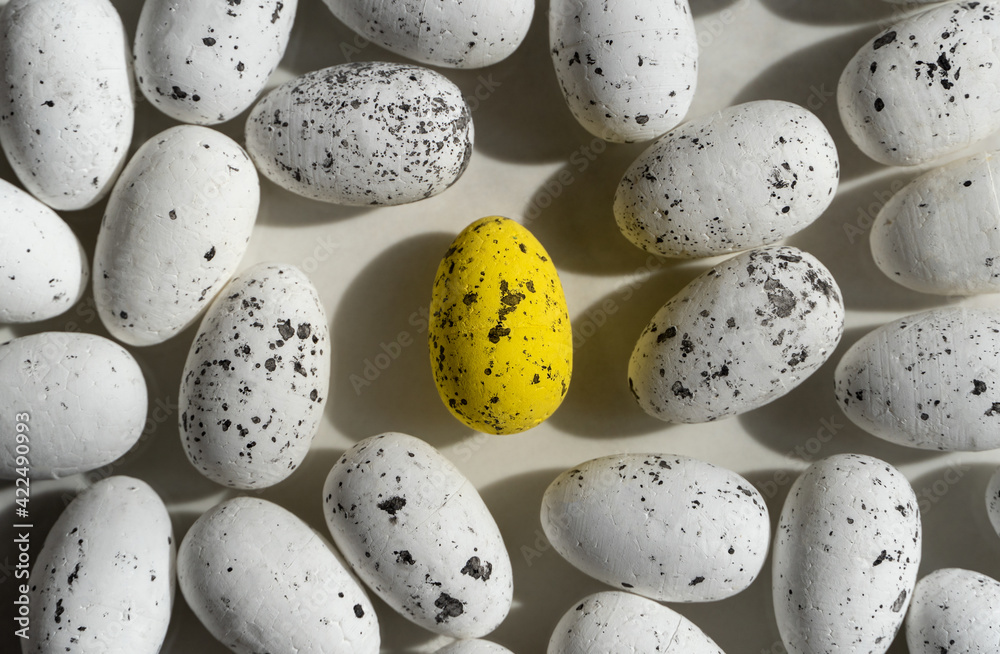 Little Easter white eggs and one yellow egg in the middle, with black elements, easter background Little Easter white eggs and one yellow egg in the middle, with black elements, easter background